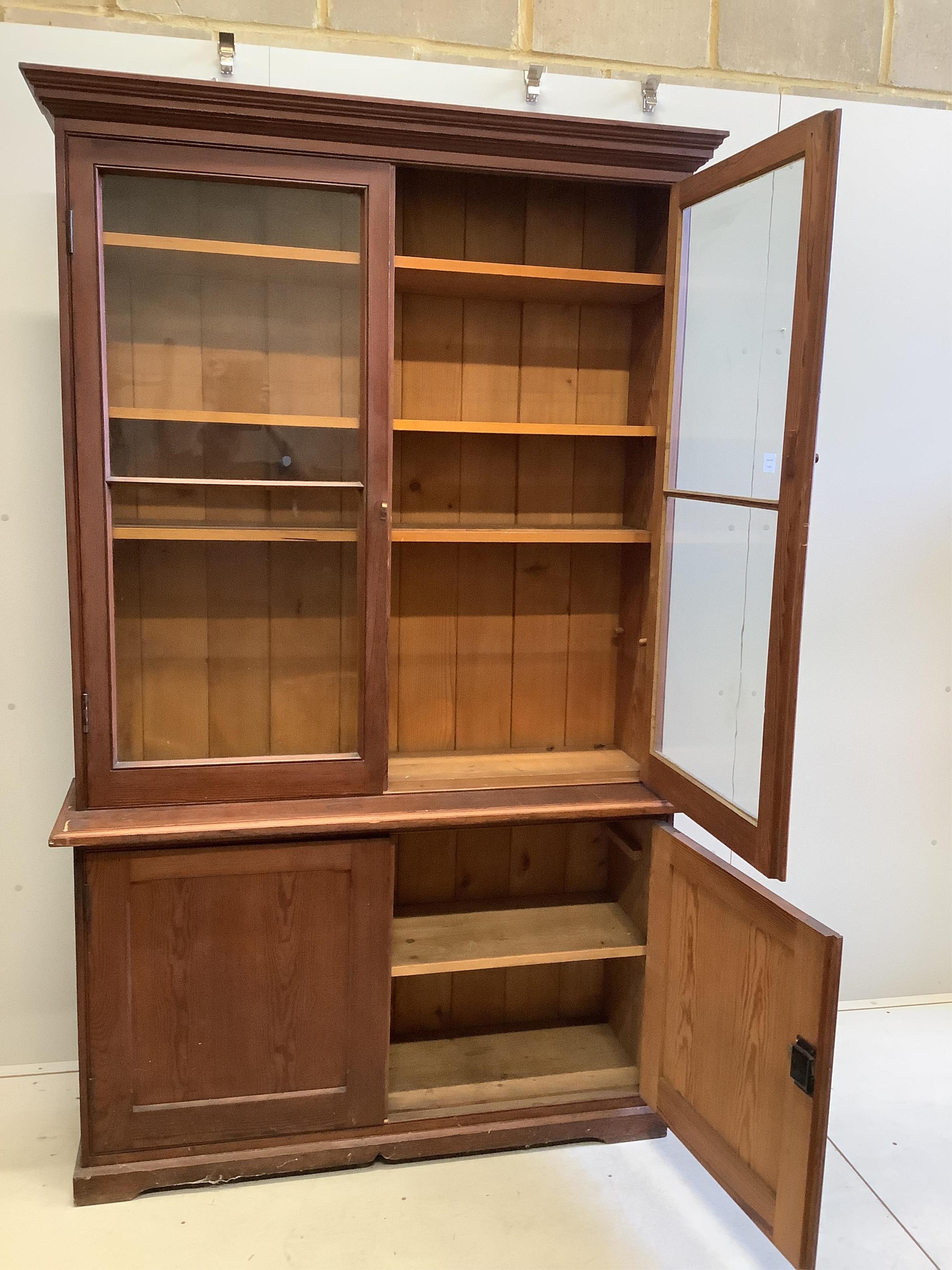 A late Victorian pine bookcase cupboard, width 130cm, depth 40cm, height 214cm. Condition - poor to fair